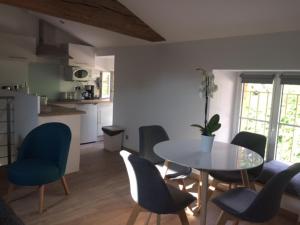 uma sala de jantar com mesa e cadeiras e uma cozinha em Gîte des Charmilles /La Maison des Gardes em Cluny