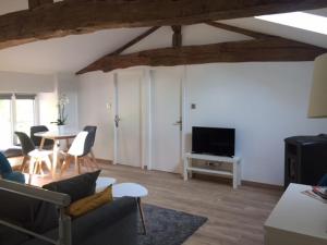 ein Wohnzimmer mit einem Sofa und einem Tisch mit Stühlen in der Unterkunft Gîte des Charmilles /La Maison des Gardes in Cluny