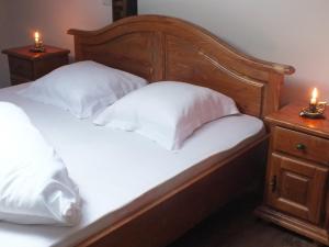 アルバ・ユリアにあるCamere de inchiriat Oneliaのベッド1台(白い枕2つ、ナイトスタンドにキャンドル2本付)