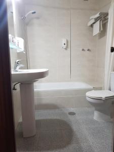 La salle de bains est pourvue d'un lavabo, de toilettes et d'une baignoire. dans l'établissement Hotel La Noria, à Lepe