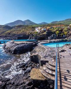 a swimming pool next to a body of water at VV EL CHARCO, El Hierro in La Caleta