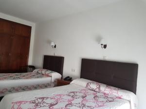 une chambre d'hôtel avec 2 lits et 2 lampes dans l'établissement Hotel La Noria, à Lepe