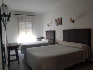 Cette chambre comprend 2 lits et une fenêtre. dans l'établissement Hotel La Noria, à Lepe