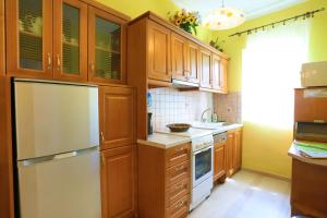 een keuken met houten kasten en een witte koelkast bij Beach House Varvara in Kassiopi