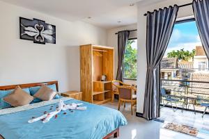 a bedroom with a bed and a balcony at Little Boss Homestay in Hoi An