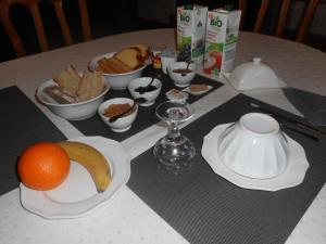 a table with a plate of food and an orange on it at LE LOGIS DE L'ETORE in Saint-Jean-dʼAngély