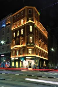 ein hohes Gebäude in der Nacht auf einer Stadtstraße in der Unterkunft Mondial Appartement Hotel in Wien