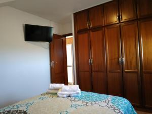 1 dormitorio con 1 cama con armarios de madera y toallas en VV EL CHARCO, El Hierro, en La Caleta