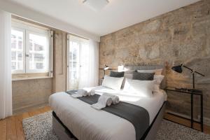 a bedroom with a large bed with towels on it at LovelyStay - Sao Domingos Apartment in Porto