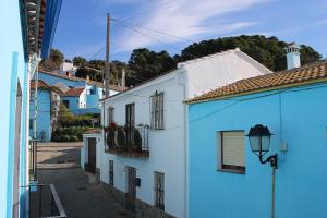 una calle con edificios blancos y un semáforo en Apartamentos Real Fábrica Hojalata, en Júzcar