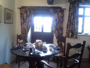 a dining room table with chairs and a window at Holmeshead Farm in Ambleside