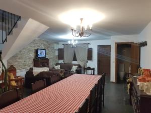 a dining room with a table and a living room at Cantinho Ti Carlos in Pitões das Júnias
