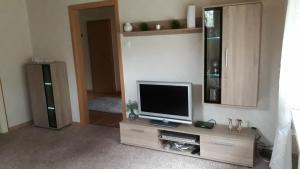 a living room with a tv on a wooden entertainment center at Ferienwohnung Bredehöft in Gnarrenburg