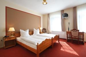 ein Schlafzimmer mit einem großen Bett mit weißer Bettwäsche in der Unterkunft Hotel-Restaurant Sälzerhof in Salzkotten