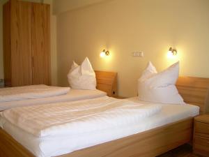 2 Betten in einem Hotelzimmer mit weißen Kissen in der Unterkunft Hotel-Restaurant Sälzerhof in Salzkotten