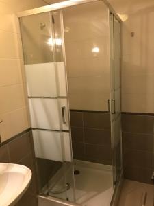 a glass shower in a bathroom with a sink at NN Guest House in Coimbra +22 photos
