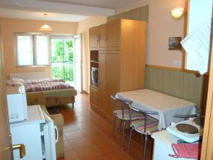 a room with a kitchen and a living room at Atlas Apartman in Bük