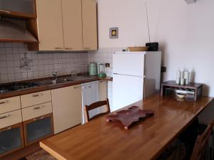 a kitchen with a wooden table and a white refrigerator at Checchi House in Rome