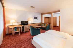 a hotel room with a bed and a living room at Hotel am Markt in Eisenach