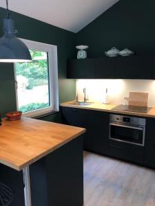 a kitchen with black cabinets and a wooden counter top at Gastenverblijf De Lorem in Leusden