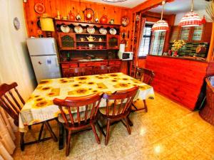 kuchnia ze stołem z krzesłami i lodówką w obiekcie Kuća za odmor "Livadica" w mieście Netretić