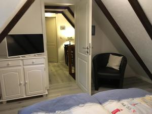 a bedroom with a bed and a tv and a chair at Witt-Dün in Tating +7 photos