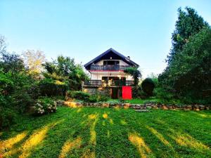 dom z czerwonymi drzwiami w ogrodzie w obiekcie Kuća za odmor "Livadica" w mieście Netretić
