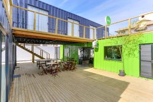 Innbox - Canasvieiras في فلوريانوبوليس: سطح السفينة مع طاولة وكراسي على المبنى