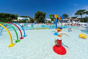 un parque acuático con una piscina con gente jugando en ella en Albatross Mobile Homes on Camping Mare e Pineta en Lido degli Estensi