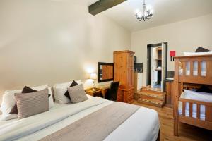 a bedroom with a large bed and a desk at Conifers Guest House in Oxford