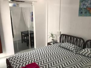 a bedroom with a bed with a black and white comforter at Villa Khatun Guesthouse in Panaji