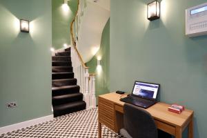 a office with a desk with a laptop on it at Kensington Stay in London