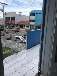 een open deur naar een balkon met uitzicht op een straat bij TRES TORRES POUSADA in Torres