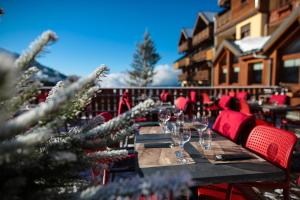 a dining table with wine glasses and a christmas tree at Hotel Lac Bleu 1650 in Saint-François-Longchamp