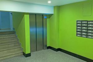 a hallway with green walls and stairs in a building at Barrón 21 in Logroño
