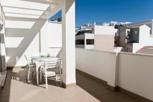 - Balcón con mesa y sillas en un edificio en Rincon Penthouse Beach Pool Terrace 2Bed, en Torre de Benagalbón