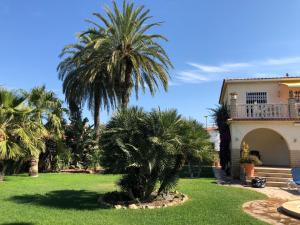 a house with palm trees in front of a yard at Villa - Casa Ines in Cambrils