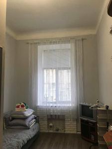 een slaapkamer met een raam, een bed en een televisie bij Cozy and comfortable apartment in Lviv