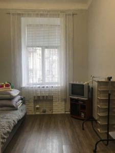 een slaapkamer met een bed, een tv en een raam bij Cozy and comfortable apartment in Lviv