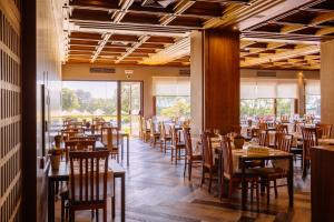 a dining room with wooden tables and chairs at Axis Vermar Conference & Beach Hotel in Póvoa de Varzim