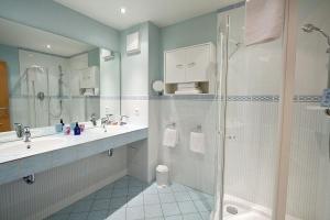 a bathroom with a shower and a sink at Vitalhotel Sonneneck in Hohegeiß +42 photos