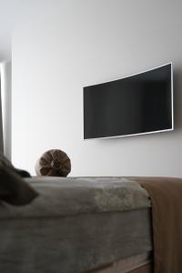 a flat screen tv hanging on a wall above a couch at Apartment Tbilisi in King David in Tbilisi City