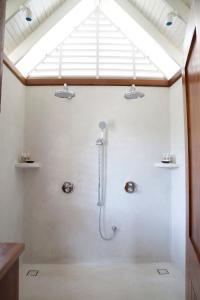 a bathroom with a shower with a skylight at GoldenEye in Oracabessa