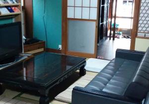 a living room with a coffee table and a couch at Guesthouse Angoso in Niigata