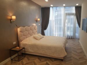 a bedroom with a bed and a large window at Apartment Tbilisi in King David in Tbilisi City