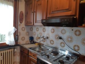cocina con fregadero y fogones horno superior en Appartamento Limone con vista, en Limone Piemonte