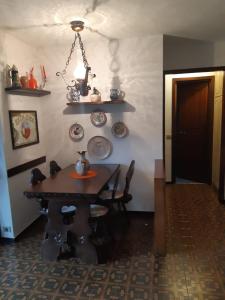 comedor con mesa y algunos platos en la pared en Appartamento Limone con vista, en Limone Piemonte