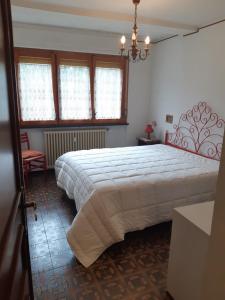 Un dormitorio con una cama grande y una lámpara de araña. en Appartamento Limone con vista, en Limone Piemonte