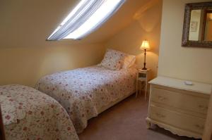1 dormitorio con cama, ventana y vestidor en Broccoli Bottom, en Oakham