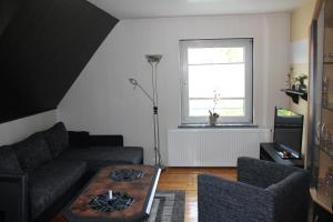 a living room with a couch and a table and a window at Surek in Soltau